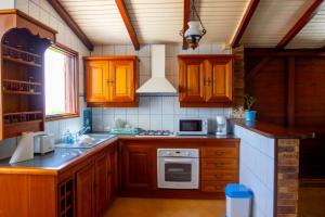 eine Küche mit Holzschränken und einem Herd mit Backofen in der Unterkunft T2 des Tortues in Bouillante