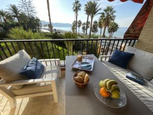 a table with a plate of fruit on a balcony at Rosa Nautica 106 in La Herradura