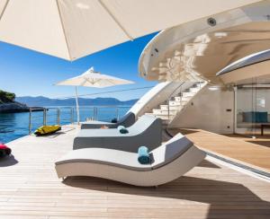 a deck of a boat with benches and an umbrella at Luxury Yacht Travels in Tokushima
