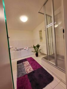uma casa de banho com um chuveiro e um tapete roxo em Pension Kricklsäge em Philippsreut