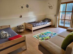 uma sala de estar com uma cama e um sofá em Pension Kricklsäge em Philippsreut