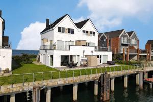 ein weißes Haus auf einem Pier neben dem Wasser in der Unterkunft Ferienwohnung-Brigantine-33-by-Seeblick-Ferien-ORO in Olpenitz