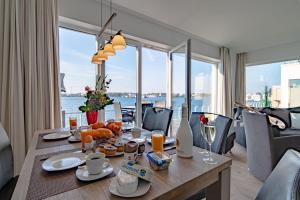 a dining room table with a view of the water at Ferienwohnung-Brigantine-33-by-Seeblick-Ferien-ORO in Olpenitz