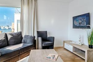 ein Wohnzimmer mit einem Sofa und einem Stuhl in der Unterkunft Ferienwohnung-Brigantine-33-by-Seeblick-Ferien-ORO in Olpenitz