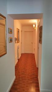 Pollena Trocchia的住宿－La Famiglia，走廊设有白色墙壁和硬木地板