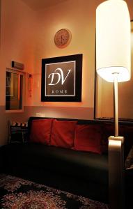 uma sala de estar com um sofá e um relógio na parede em DolceVeneto Rooms & Suites em Roma