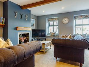 a living room with a couch and a clock on the wall at The Lookout in Holmfirth