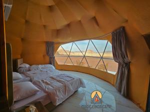 una camera con letto e finestra in una tenda di wadi rum,Linda Camp a Wadi Rum