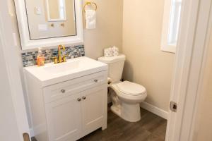 un bagno con un water, un lavandino e uno specchio di Waddle on Inn- Hot Tub, Pet Friendly, Fully Fenced, 5 Blocks to Beach! a Ocean Park Altre 24 foto