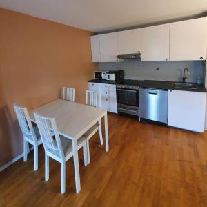 a kitchen with a table and chairs in a room at Bedroom in apartment 12 minutes to Oslo City by train in Oslo