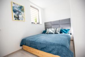 a bedroom with a bed with a blue comforter at Wlodarska 4a Lux Premium in Kraków