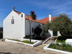 a small white church with a red roof at Casa da Quinta do Outeiro in Reveles