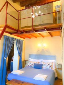 1 dormitorio con cama azul y loft en Ca' Tomassino Holiday Apartments, en Urbino