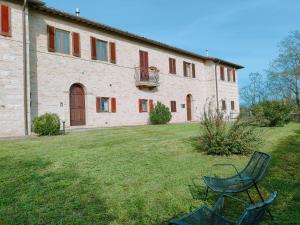 un bâtiment avec deux chaises devant lui dans l'établissement Ca' Tomassino Holiday Apartments, à Urbino