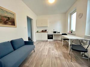 ein Wohnzimmer mit einem blauen Sofa und einer Küche in der Unterkunft Studio Apartments nahe Stadt in Neumünster