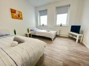 1 Schlafzimmer mit 2 Betten und 2 Fenstern in der Unterkunft Studio Apartments nahe Stadt in Neumünster