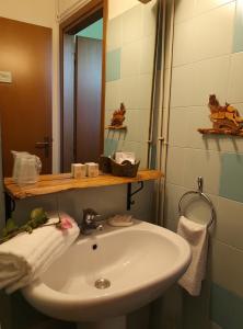 Un baño con un lavabo blanco y un espejo. en Ca' Tomassino Holiday Apartments, en Urbino