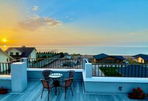 博斯特里的住宿－Alma Villa Guest House - Bosteri，阳台配有两把椅子和一张桌子,享有海景。