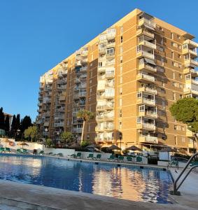 un gran edificio de apartamentos con piscina frente a él en Attico Acuario, 2 bathrooms Top Floor appartment with Sea and mountain views, en Benalmádena