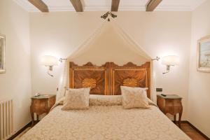 a bedroom with a large bed with a wooden headboard at Rigat Park & Spa Hotel - Adults Recommended in Lloret de Mar