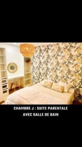 a bedroom with a white bed with a floral wallpaper at Maison Piscine Spa près bordeaux in Ambarès-et-Lagrave