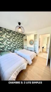 duas camas num quarto com flores na parede em Maison Piscine Spa près bordeaux em Ambarès-et-Lagrave