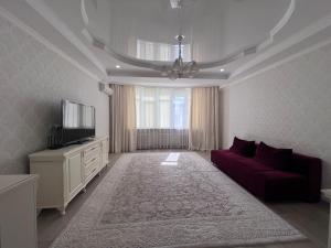 比什凱克的住宿－Абрикос，客厅配有红色沙发和电视