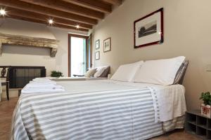um quarto com uma cama grande e lençóis brancos em B&B Borgo Re Teodorico em Verona