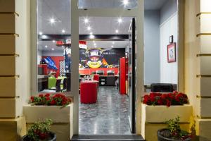 a fire department lobby with red flowers in the doorway at Enzo Hotels Contrexeville by Kyriad Direct in Contrexéville