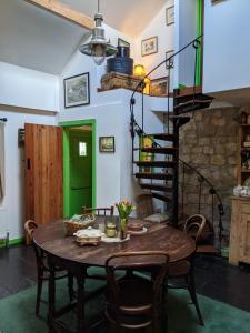 a dining room with a table and a spiral staircase at Turrock Cottage in Shillelagh