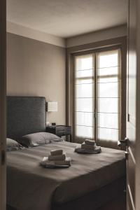 1 dormitorio con 1 cama con 2 toallas en Réva Resort, en Monforte dʼAlba