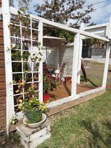 una pérgola blanca con macetas en un patio en Yaka, en Saint-Paul