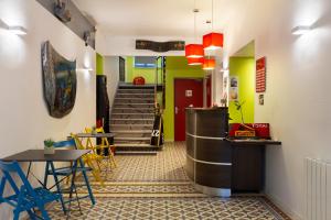 a hallway with a table and chairs and stairs at Enzo Hotels Contrexeville by Kyriad Direct in Contrexéville