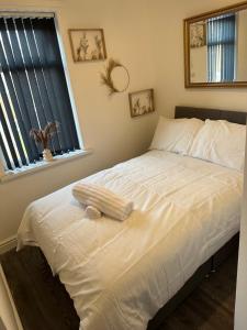 - un lit blanc dans une chambre avec fenêtre dans l'établissement Short Stayzzz, à Manchester