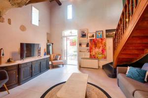 sala de estar con sofá y TV y escalera en LOASIS- Maison Provençale T4 proche Aix en Pce, en Meyrargues