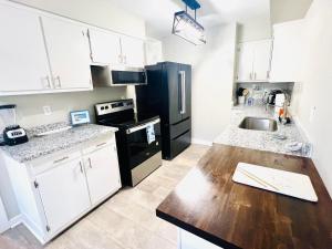 a kitchen with white cabinets and a wooden counter top at 4/2 Home Close to Beach, Centrally located! in Gulfport