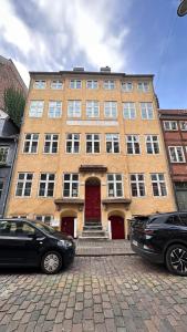 a building with two cars parked in front of it at Boutique Apartments 1 - 8 in Copenhagen