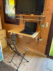 un ordenador portátil sentado en un escritorio con una silla en Casa Nuvola, en SantʼAndrea