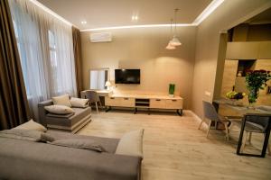 a living room with a couch and a desk with a television at Apart-Hotel CARDINAL in Truskavets