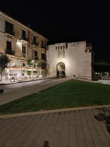 uma rua vazia em frente a um castelo à noite em Al Settimo porta marina em Siracusa