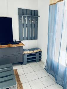 a room with a tv and a bench in a room at Villa Longani Passion pour des vacances bucoliques en famille in Petite Île