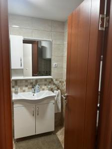 een badkamer met een wastafel en een spiegel bij No1Apartments in Požarevac