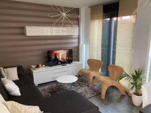 a living room with a couch and a tv at RURAL3MIJAROJOS casa con jardin y piscina privada en el centro de Cantabria 