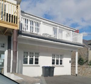 a white house with a balcony on top of it at 1 Golf Mews in Ballater