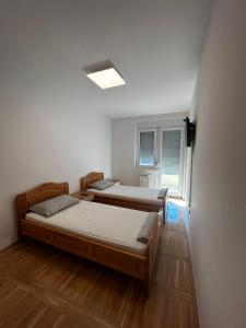 twee bedden in een kamer met een raam bij No1Apartments in Požarevac