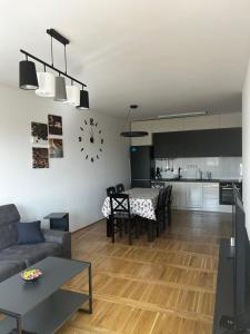 a living room and kitchen with a table and a clock at No1Apartments in Požarevac