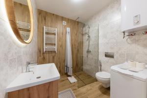 y baño con lavabo, ducha y aseo. en Luxury Apartments CITY en Úzhgorod