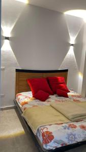 ein Schlafzimmer mit einem Bett mit roten Kissen darauf in der Unterkunft Red Ruby Compound منتجع الياقوتة الحمراء in Hurghada