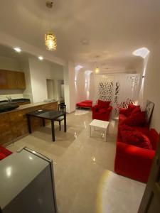ein Wohnzimmer mit roten Sofas und einem Tisch in der Unterkunft Red Ruby Compound منتجع الياقوتة الحمراء in Hurghada