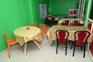 a room with tables and chairs and green walls at HOTEL BEACH A/C in Port Blair